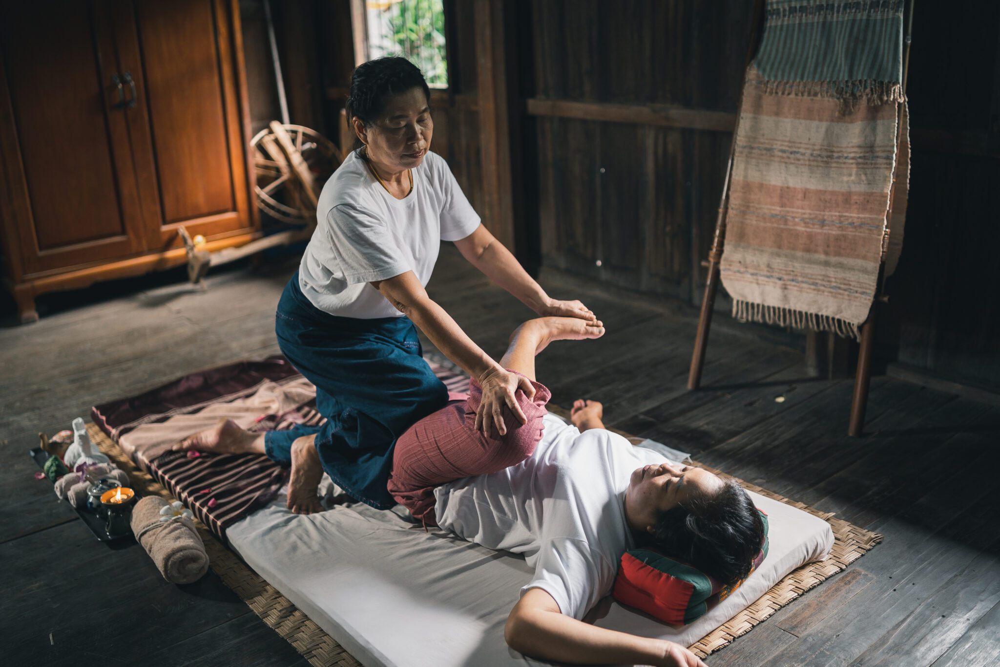 Frau während einer traditionellen Thai-Massage auf einer Matte