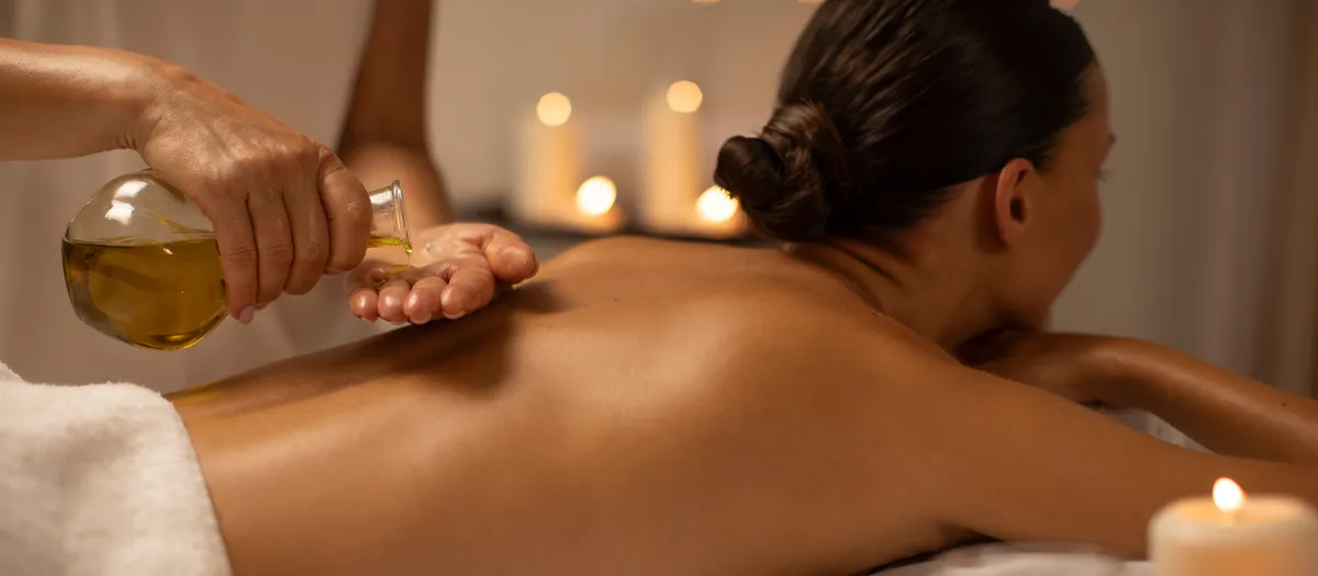 Frau genießt eine entspannende Öl-Massage mit warmen Öl auf einer Massageliege