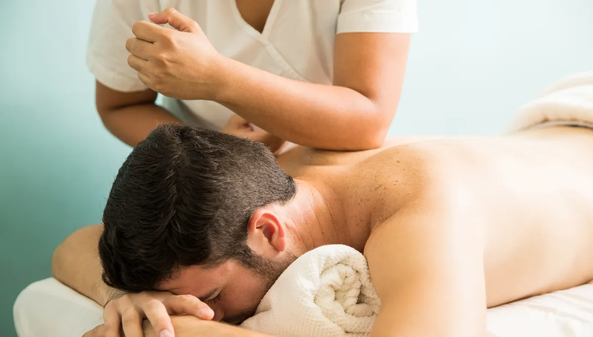 Ein Mann erhält eine Rückenmassage der der Verspannungen gelöst werden