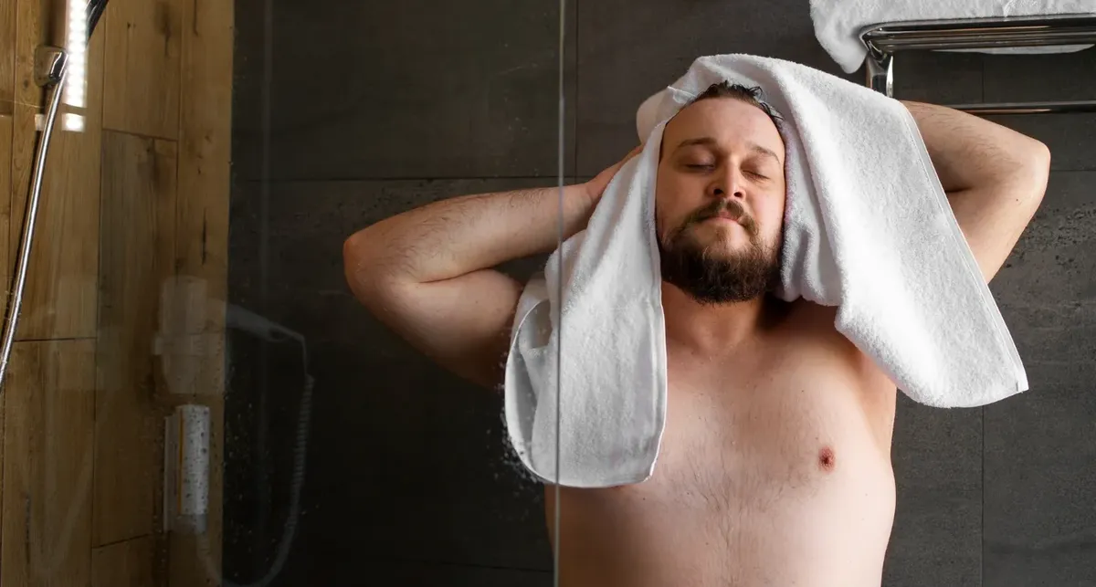 Ein Mann duscht, um sich auf eine traditionelle Thai-Massage vorzubereiten